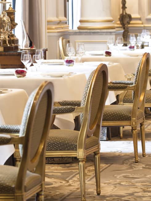 Le Cinq is ready for guests with square tables set with crystal glasses, napkins and tableware