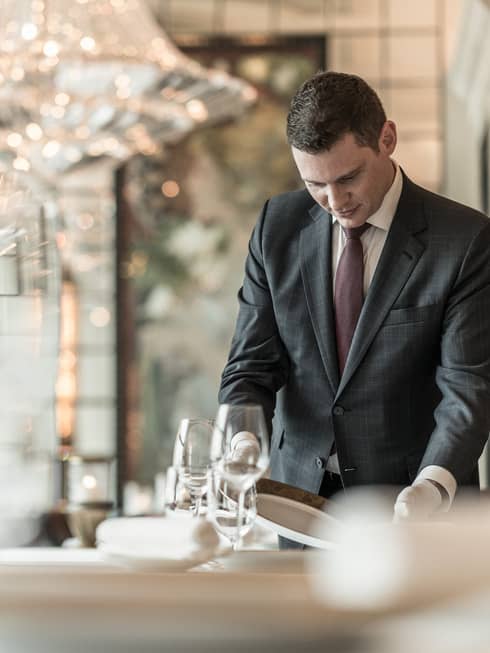 A four seasons waiter sets the table at Caprice