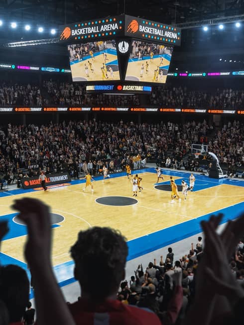 Professional basketball game being watched by a stadium full of people