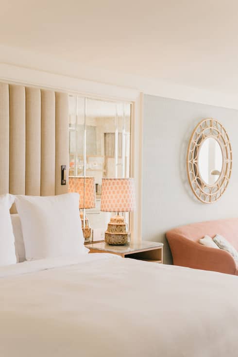 Pink accents highlight a bright beachside bedroom