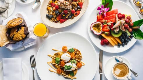 Aerial view of gourmet brunch dishes, fresh fruit platters arranged on table