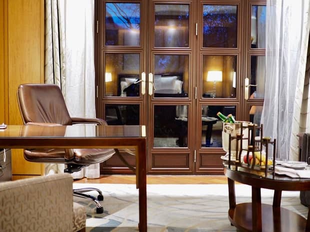 Work desk with brown leather swivel chair by glass patio door at night