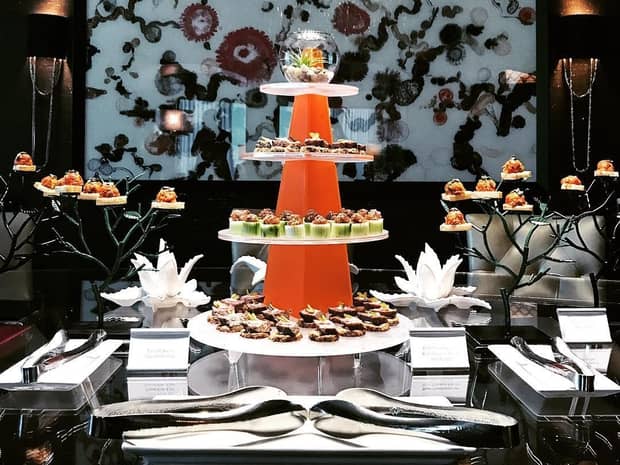 Modern tiered tray with canape appetizers on decorative table