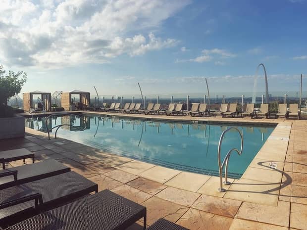 Rooftop outdoor swimming pool lined with deck chairs 