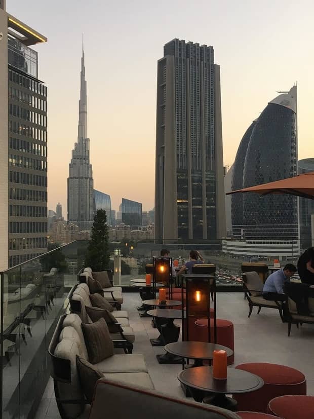 Lounge chairs along Four Seasons International Financial Centre hotel rooftop patio at sunset