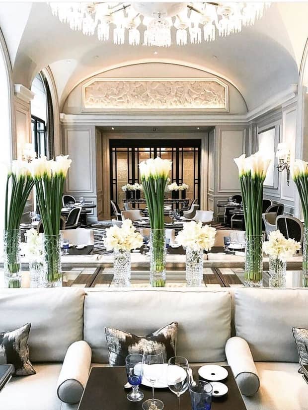 Dining room, white sofas, tables, long-stemmed flowers under dome ceilings, chandeliers
