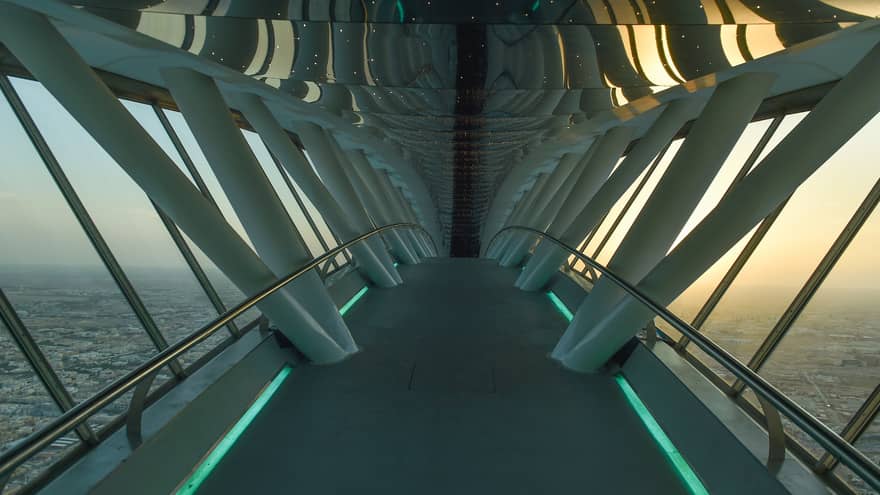 Looking down through white Sky Bridge, city far below