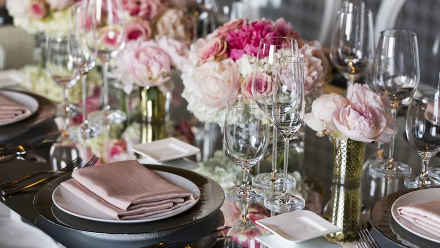 Close-up of wedding table place setting decorated with pink roses, linens 