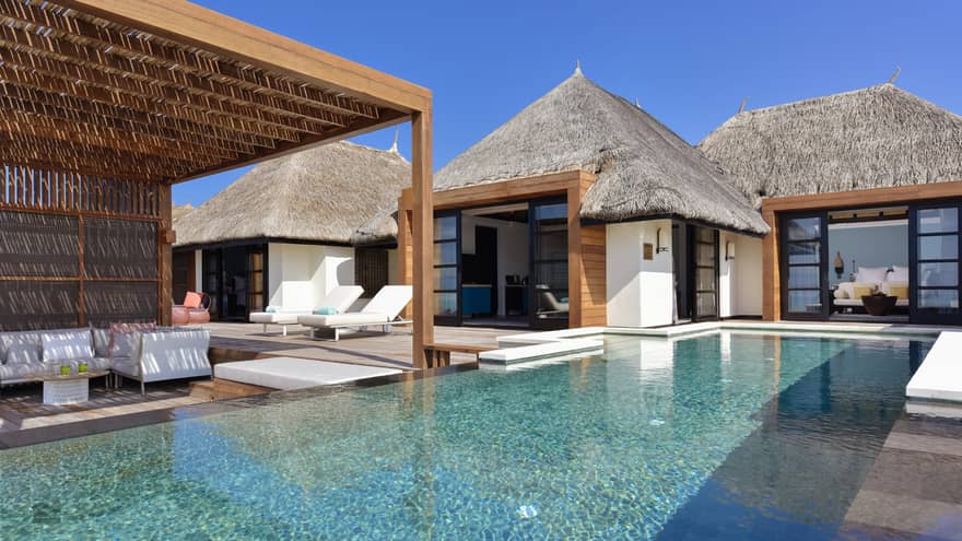 Luxury two-bedroom water suite with a private pool, sun loungers and thatched roofs