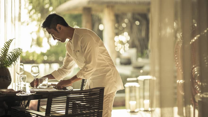In-villa dining being set up by staff member