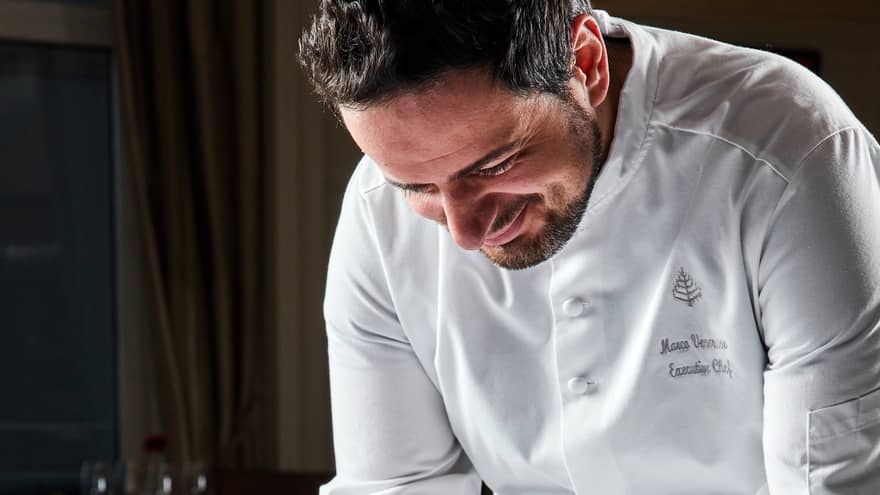 Chef Marco in white chef's coat plating a Valentine's dessert