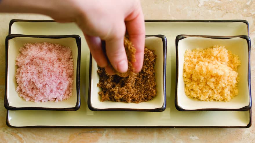 Three dishes with pink, brown and yellow spa body salt scrubs