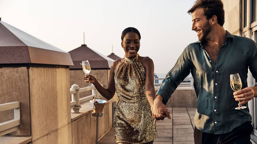 A man and woman on a balcony with wine.