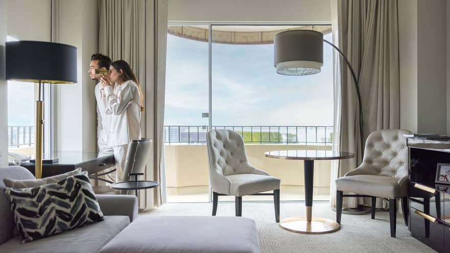 Two guests looking out of the window of their guest room