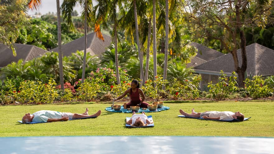 A group doing yoga and meditation outside.