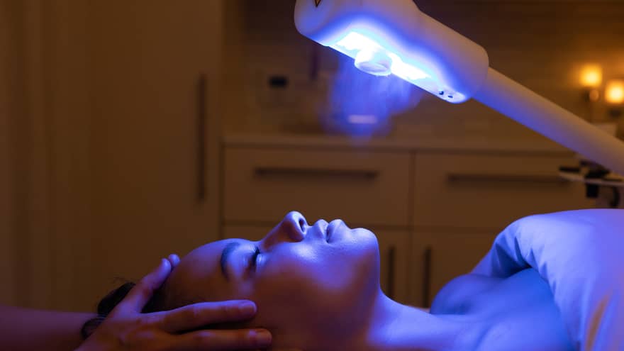 A guest laying on a spa table and receiving a light therapy treatment 