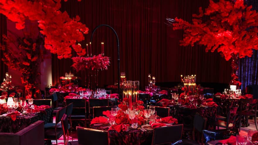 Dining room with red lights and table settings with candles.
