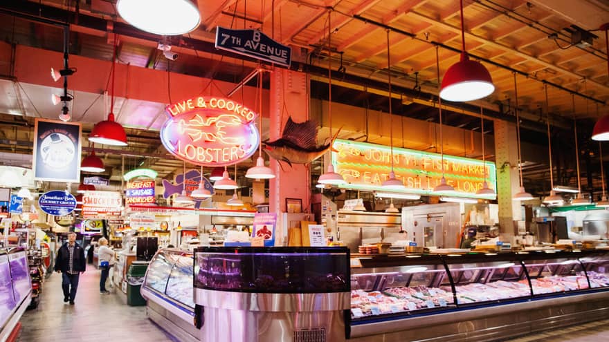 A large indoor market featuring fresh seafood behind glass windows.