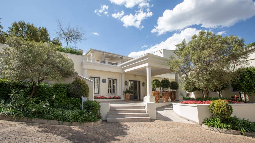 White building with steps leading up surrounded by trees