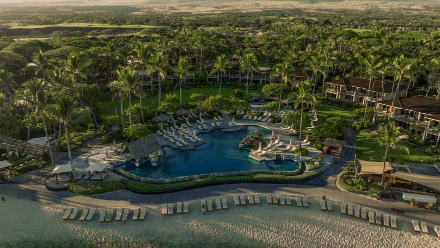 Aerial view of a tropical resort pool, set next to beach