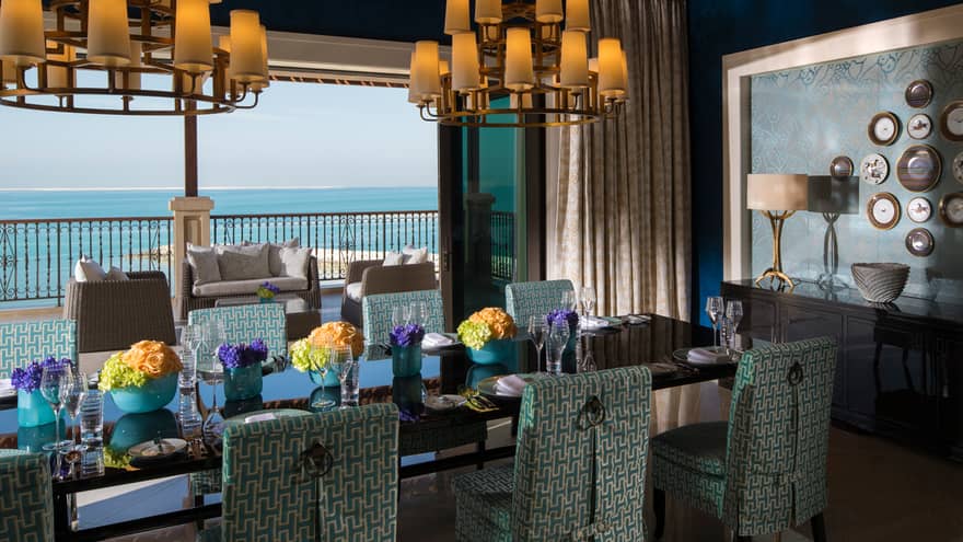 Presidential Suite formal long dining table with blue-and-white chairs, patio with beach views