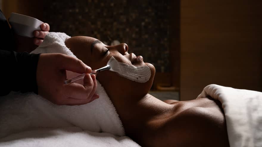 Guest laying on a massage table while getting a facial.