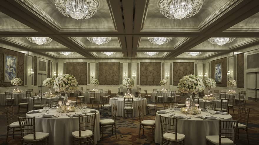 Round tables under crystal chandeliers in elegant Ocean Ballroom event space 