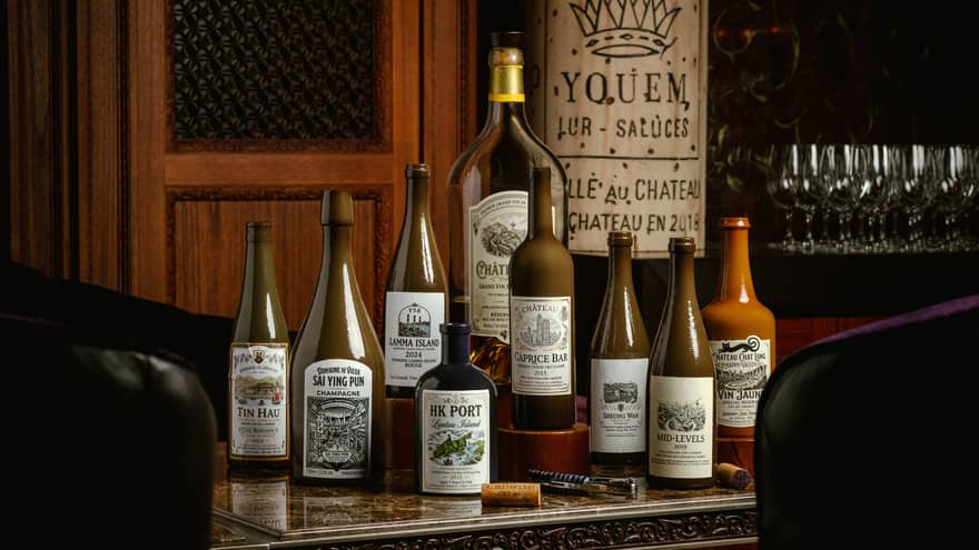 Collection of 9 labeled bottles set on a bar counter