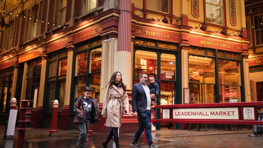 A family walks through London city street at night