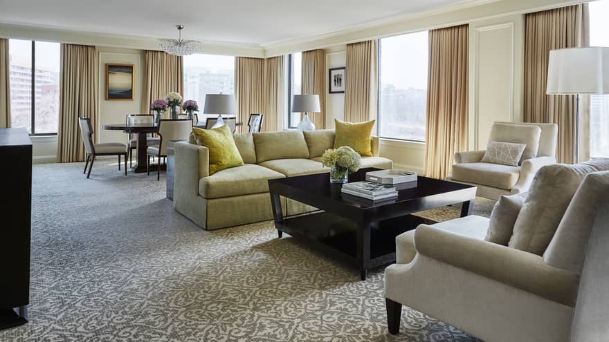 Presidential Suite East Wing dining table, living room with side of yellow sofa, two white armchairs 