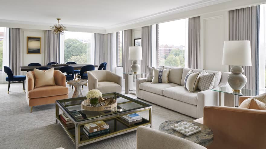 Plush sofa and chairs bathed in natural light in the living room of the Presidential Suite