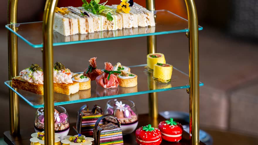 A tiered serving tray holds an assortment of colourful small bites.