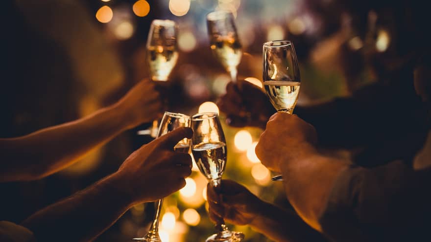 Numerous hands holding champagne flutes with champagne celebratory toast silhouettes