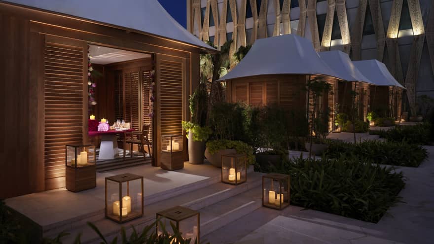 A series of lanterns illuminating the steps into a private bungalow