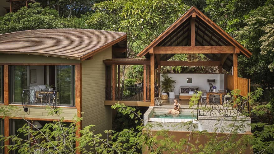 The Canopy Suite sits perched within the trees, with a bedroom connected by open-air walkway to a covered outdoor living area and plunge pool