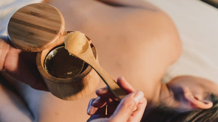 A spa scrub is placed on a guest's back during a relaxing treatment