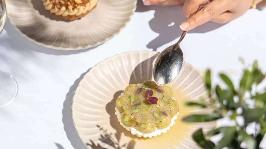 Two people partake of elegant desserts on artistic scallop-edged plates.
