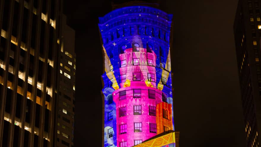 City building with a projection of lights on it.