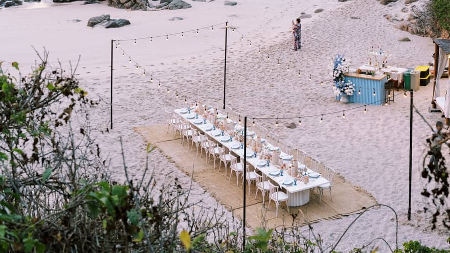 Aerial view of group dining table setup on the beach
