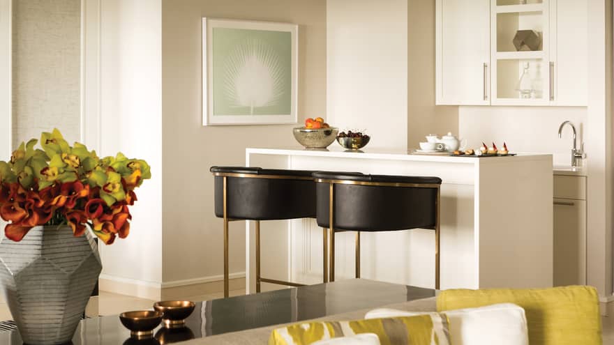 Grand Suite wo modern black stools at small white bar with bowls of fresh peaches, cherries, tea service
