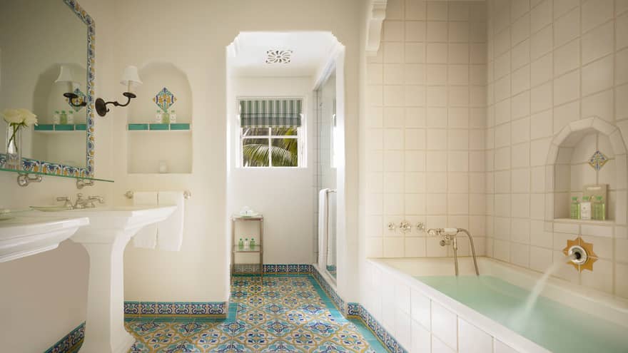 White tile bathroom, long tub, colourful Spanish Colonial-style tiles 