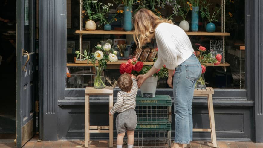 One guest helping younger guest reach for a bouquet of flowers.