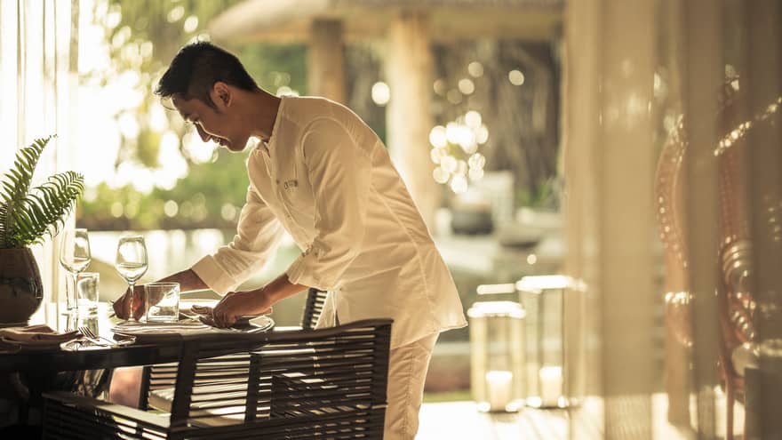 In-villa dining being set up by staff member
