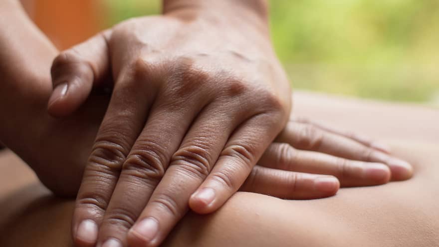 Close up of hands massaging a back
