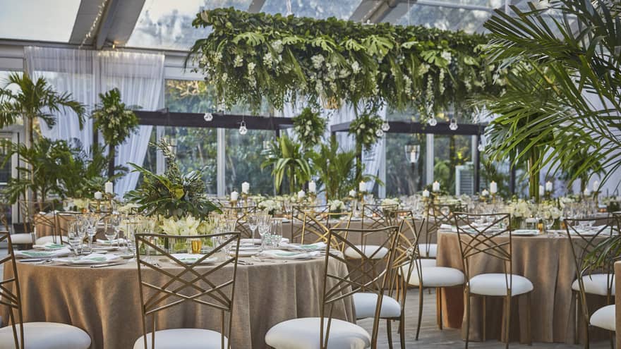 Wedding banquet, round dining tables with tropical greenery