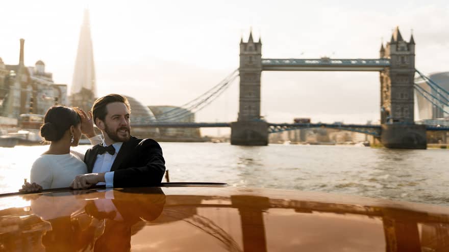 A couple enjoy on a romantic river cruise, surrounded by iconic city landmarks.