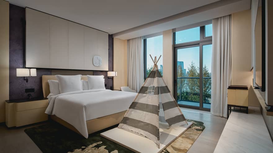 Luxury hotel suite bedroom with king bed and kids tent at Four Seasons Hotel Suzhou
