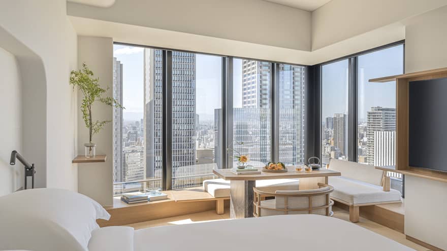 Luxurious guest room at Four Seasons Hotel Osaka with skyline views, modern decor, and serene seating area.