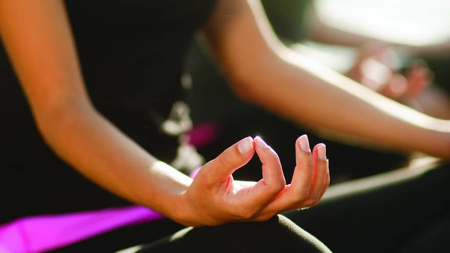 Two women sitting in a yoga pose.