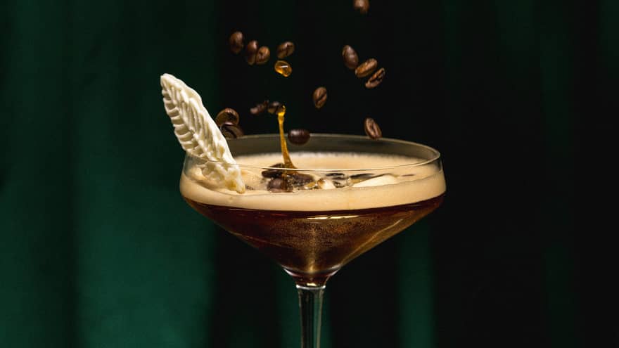 A cocktail with coffee bean garnish.